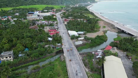 Virac-En-El-Centro-De-Catanduanes,-Filipinas,-Mostrando-La-Carretera-Costera,-El-Río-Y-La-Exuberante-Vegetación,-Vista-Aérea