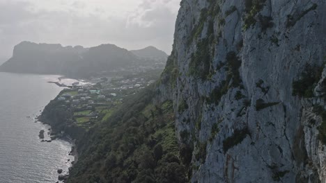 Küstenblick-Auf-Capri-Mit-Steilen-Klippen-Und-Verstreuten-Häusern,-Unter-Bewölktem-Himmel