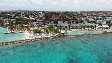 Jan-thiel-beach-with-clear-turquoise-water-in-curacao,-luxury-resort-area,-aerial-view