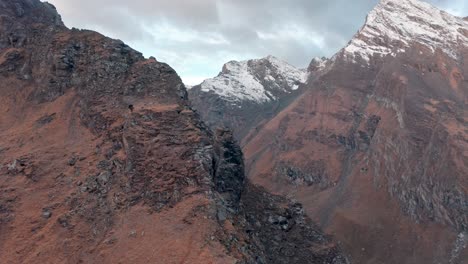 Rugged-mountain-peaks-with-snow-under-a-soft-sky-at-dawn,-a-sense-of-serene-wilderness