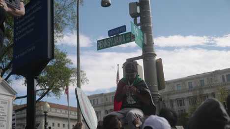 Ein-Arabischer-Mann-Sitzt-Auf-Einer-Straßenlaterne-Auf-Der-Pennsylvania-Avenue-Und-Bindet-Eine-Palästinensische-Flagge-An