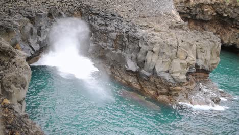 Waves-breaking-against-a-marine-cave-in-Porto-da-Cruz,-Madeira