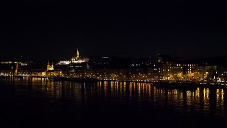 Budapest-city-center-view-and-Danube-river-at-night,-light-reflections,-wide-panoramic-shot