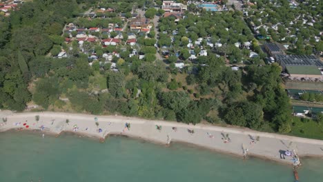 Vista-Aérea-De-La-Playa-Y-El-Camping-Fossalta-En-La-Orilla-Del-Lago-De-Garda,-Italia