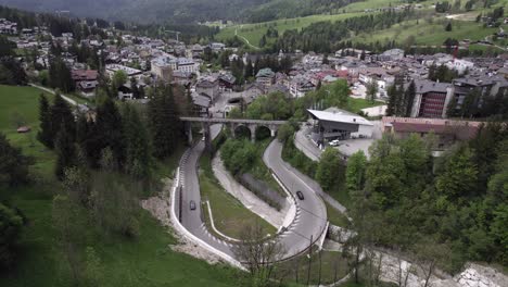 Cars-driving-around-hairpin-bend-Cortina-D'Ampezzo,-Italy