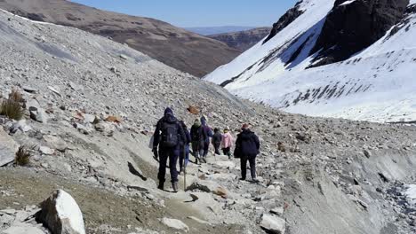 Tourist-group-on-alpine-mountain-hike-in-Bolivian-Andes,-snowy-slopes