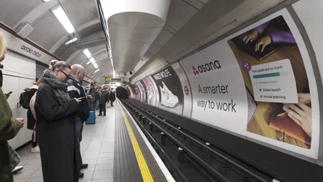 Passengers-waiting-for-the-arrival-of-the-Bakerloo-Line-train-at-the-platform-of-Oxford-Street-station-in-London,-England