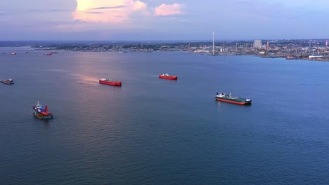 Vista-Aérea-Panorámica-De-Los-Petroleros-Y-La-Refinería-De-Petróleo-De-Pertamina-En-El-Fondo-Durante-La-Puesta-De-Sol---Puerto-De-Balikpapan---Kalimantan-Oriental,-Indonesia