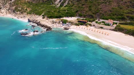 Petani-beach-with-turquoise-waters-and-rocky-shores-in-kefalonia,-greece,-during-daylight,-aerial-view