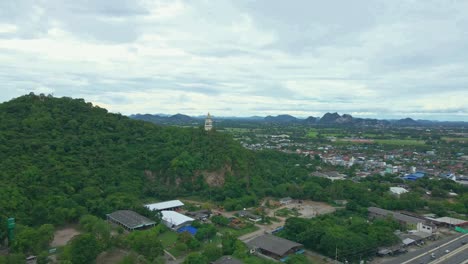 Aerial-View-Across-Ratchaburi's-Province-with-Scenic-Landscape-and-a-Clock-Tower-on-a-Hilltop-Overlooking-a-Town-in-the-Background