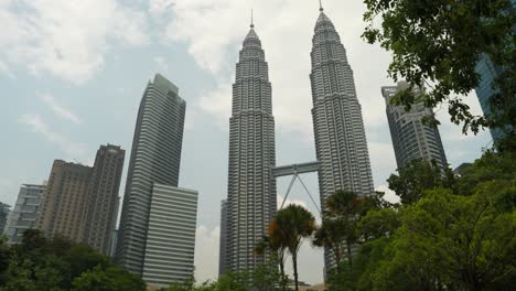 Vegetación-Tropical-Que-Enmarca-Las-Torres-Petronas-En-Kuala-Lumpur,-Día-Soleado