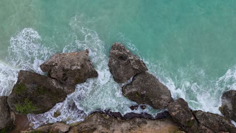 Descenso-Aéreo-Sobre-Aguas-Turbulentas-Que-Se-Derraman-Entre-Rocas-Rocosas-Costeras,-Vista-De-Pájaro