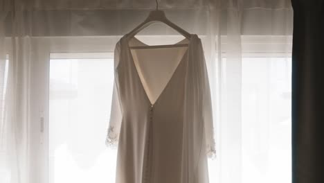 Elegante-Vestido-De-Novia-Colgado-Frente-A-Una-Ventana