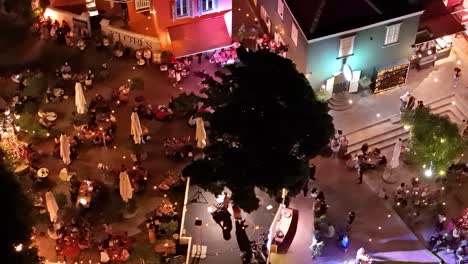 Aerial-orbit-high-angle-around-fashion-show-and-people-eating-at-plaza-in-Kura-Hulanda-village-in-Otrobanda-Willemstad-Curacao