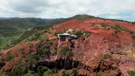 Rotating-Drone-View-Reveals-Mirador-de-Abrante,-Red-Rocky-Formations-and-Backdropped-by-Lush-Green-Mountains,-La-Gomera