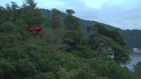 Destacando-Las-Verdes-Montañas-Que-Rodean-El-Lago-Kawaguchiko-En-Japón,-Una-Puerta-Torii-Se-Erige-Como-Símbolo,-Lo-Que-Significa-Lo-Sagrado-De-Esta-Zona-Montañosa.