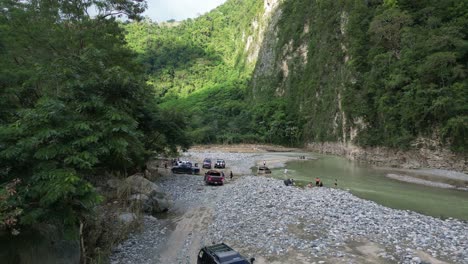 People-with-Off-road-vehicles-4x4-relaxing-on-shores-of-river,-Muchas-Aguas-in-Dominican-Republic