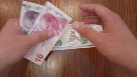 Ein-Teenager-Sortiert-Jede-Türkische-Lira-Banknote-Nach-Wert,-Mit-Einem-Porträt-Von-Atatürk,-Dem-Gründer-Der-Republik-Türkei,-Obenauf