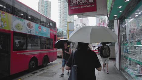 Mong-Kok-area-of-Hong-Kong-street-level-view-of-pedestrians-and-city-traffic-on-a-busy-overcast-rainy-day---handheld-camera