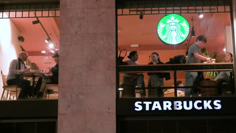 Se-Ve-A-Los-Clientes-Consumiendo-En-La-Tienda-De-Café-Starbucks-De-La-Cadena-Multinacional-Estadounidense