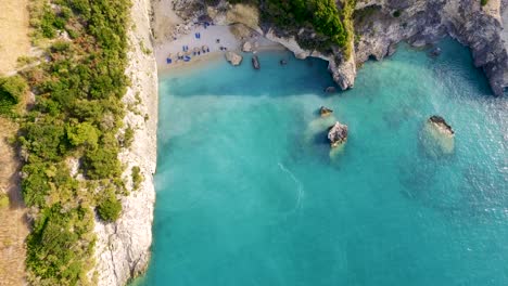 Aerial-shot-of-Xigia-beach-in-Zakynthos,-Greece-with-turquoise-waters-and-visitors-enjoying-the-sun
