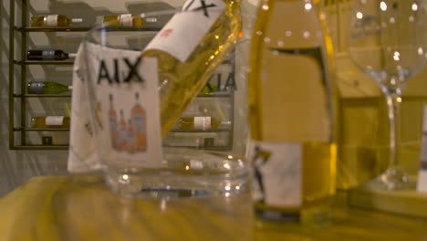 White-wine-bottle-on-wooden-table,-viticulture-scene,-focus-pull