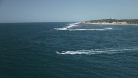 Aerial-tracking-shot-of-a-small-boat-sailing-off-the-coast-of-mozambique