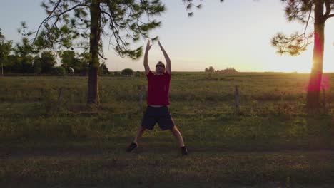 Young-man-doing-stretching-exercises-to-relax-and-get-fit-in-nature-at-sunset