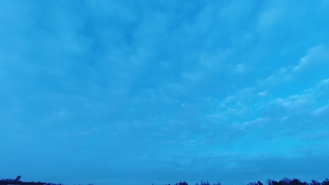 Großer-Himmel-Im-Zeitraffer:-Dünne-Wolken-Ziehen-In-Der-Abenddämmerung-über-Den-Tiefblauen-Himmel