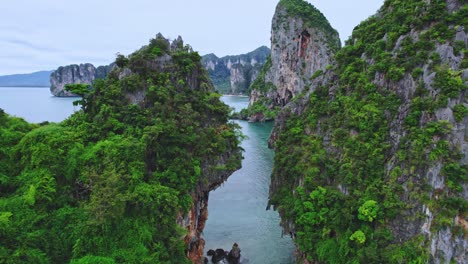 Drone-Aéreo-Volando-A-Través-De-Un-Espacio-De-Rocas-Calizas-A-Lo-Largo-De-La-Playa-De-Phra-Nang-En-Railay,-Tailandia