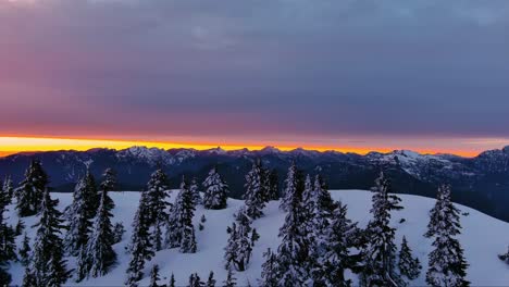 Malerische-Schneebedeckte-Berg--Und-Baumlandschaft,-Farbenfroher-Sonnenuntergangshimmel