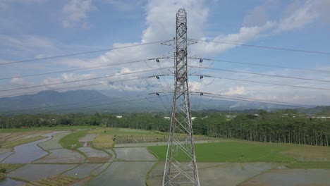 Disparo-De-Drone-Helicoidal-De-Una-Torre-Eléctrica-De-Alto-Voltaje-Construida-En-Medio-De-Una-Plantación-De-Arroz