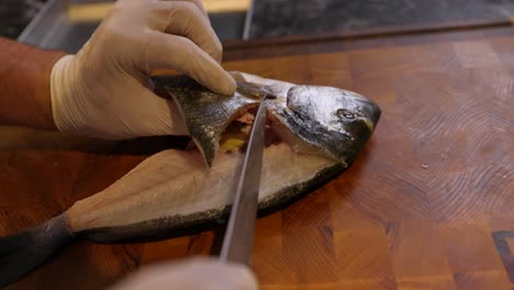 Chef-Skilfully-Slicing-And-Filleting-Fish-On-Cutting-Board