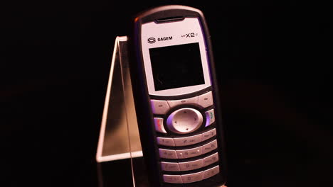 Sagem-Myx2-2-Pequeño-Teléfono-Móvil-Antiguo-De-La-Década-De-2000-Con-Giro-En-Primer-Plano-Y-Fotograma-Completo