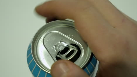 Closeup-view:-Male-right-hand-opens-pull-tab-on-aluminum-drink-can