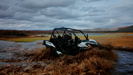 Buggy-driving-through-a-small-pond-into-nordic-wild-landscape