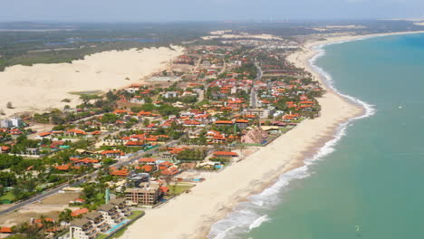 Aerial-view-of-the-sea,-waves-and-a-small-village,-Cumbuco,-Ceara,-Brazil