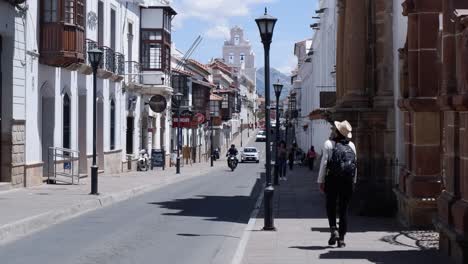 Frau-Geht-Auf-Schmaler-Stadtstraße-In-Richtung-Kathedrale-In-Sucre,-Bolivien