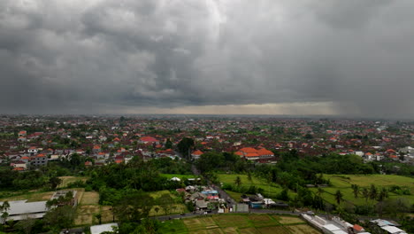 Bad-weather-over-Bali-countryside-with-city-center-in-background-on-cloudy-day,-Indonesia