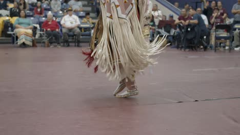 Bailarines-Nativos-Americanos-Realizan-Intrincados-Movimientos-Con-Atuendos-Tradicionales,-Adornados-Con-Símbolos-De-Espiritualidad-Y-Significado-Cultural-En-El-Powwow-De-La-Universidad-Haskell-De-Las-Naciones-Indias-En-Lawrence,-Kansas.