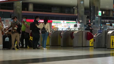 Pasajeros-Que-Viajan-Con-Equipaje-Acceden-Al-Aeropuerto-Conectando-Redes-En-La-Sala-De-Llegadas-Y-Salidas-De-La-Estación-De-Tren-De-Alta-Velocidad-De-Taoyuan,-Turismo-En-Taiwán,-Toma-Estática-En-La-Puerta-De-Barreras-De-Boletos