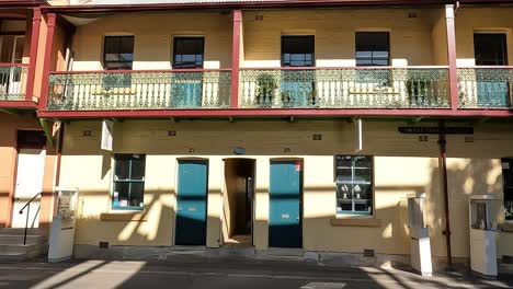 Terraza-Histórica-Iluminada-Por-El-Sol-En-The-Rocks,-Sydney,-Con-Balcones-De-Hierro-Ornamentados-Y-Arquitectura-Patrimonial