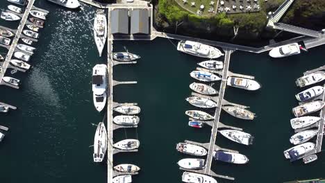 Beaucette-Marina-Guernsey-overhead-rising-shot-of-boats-berthed-on-pontoons-in-marina-on-bright-sunny-day