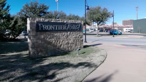 Frontier-Texas-sign-with-cars-driving-by-in-Abilene,-Texas-and-stable-video