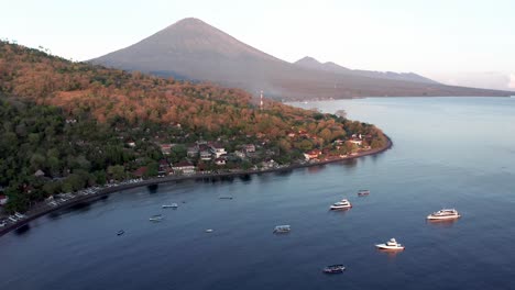 Bali-coastal-town-of-Amed-with-Mount-Agung-in-background-with-sunrise-light,-Indonesia