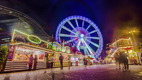 Time-lapse-of-DOM-fun-fair-vibrant-night-life-with-Ferris-wheel-in-background