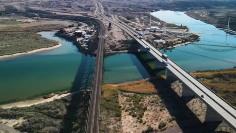 Automóviles-Y-Camiones-Circulando-Sobre-Un-Puente-Que-Cruza-El-Río-Colorado,-Autopista-I-40-Este,-Largas-Sombras,-Verano,-Estableciendo-Drones-De-Gran-Angular