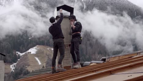 Men-dressed-as-chimney-sweeps-during-the-Stilzer-Pfluagziachn-parade-pretend-to-clean-a-chimney