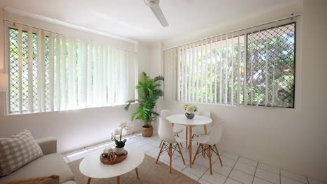 Compact-tropical-living-room-gathering-area-with-couch-table-and-chairs-in-tropical-setting