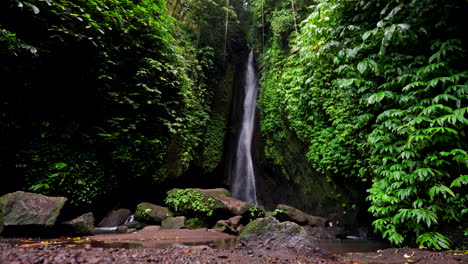 Surrounded-by-tall-greenery-and-vibrant-foliage,-Leke-Leke-Waterfall